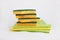 Rags and yellow-green sponges for washing dishes and kitchens are in a pile on a white background. Cool plan. The concept of
