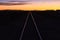 Rail track through the desert at sunset