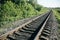 Rail tracks in the green field. Railway transport industry. Empty road on summer day. Travel lifestyle motivation photo