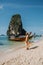 Railay Beach Krabi Thailand, woman on vacation in tropical Thailand, with tropical cliffs and long tail boats