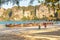 Railay, Thailand - February 19, 2019: A man photographs the boat on the beach crouching on one knee. Wide sandy tropical beach