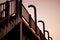 Railings of an old pedestrian bridge against the sunset s