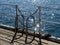 Railings on a sea pier and glittering water