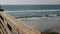 Railings of wooden pier, waterfront boardwalk, California beach USA. Defocused ocean, sea waves.