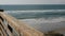 Railings of wooden pier, waterfront boardwalk, California beach USA. Defocused ocean, sea waves.