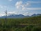 Railroad in Abisko national park with birch forest and snow capped mountains, summer blue sky clouds