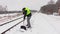 Railroad employee clean snow near the platform