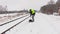 Railroad employee clean snow near railway and walking away