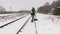 Railroad employee clean snow from the platform near railway