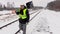 Railroad employee with snow shovel on railway