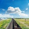 Railroad with empty wagons and clouds in blue sky