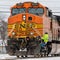 A railroad engineer climbs aboard BNSF 5045 waiting on a through signal