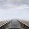 Railroad in fog to horizon in clouds