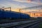 Railroad infrastructure during beautiful sunset and colorful sky, trains and wagons, transportation and industrial concept