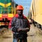 Railroad man in uniform and red hard hat with computer