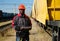 Railroad man in uniform and red hard hat with computer