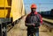 Railroad man in uniform and red hard hat with computer