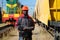 Railroad man in uniform and red hard hat with computer