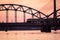 railroad metal bridge silhouette over river of Daugava in Riga,