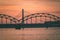 railroad metal bridge silhouette over river of Daugava in Riga,