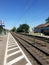 A railroad seen from a small train station. Two tracks.