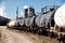 Railroad tank cars parked on a factory rail siding.