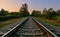 Railroad track against sunset sky