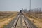 Railroad track leading through the desert. Train is coming