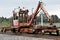 A railroad track tie crane travels on a main line