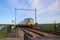 Railroad track with yellow blue dutch double decker train between Gouda and Rotterdam at Moordrecht.