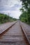 Railroad Tracks with Cloudy Sky and Power Lines In Portrait Mode