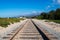 Railroad tracks converging in perspective into the distance towards distant mountains