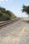 Railroad tracks curving around a bend on a gravel path