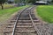 Railroad tracks curving into park older weathered ties moving into distance