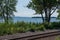 Railroad tracks on the edge of Lake Champlain with trees and crushed stone