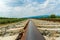 Railroad tracks leading to endless infinity. Meadow landscape and distant mountains.