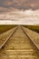 Railroad tracks running into a distant cloudy horizon