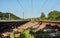 Railroad tracks, some plants growing between ties, low angle view, blurred countryside background