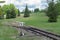 Railroad tracks stretches and green grass and trees. Railway road environment background..End of the rail.