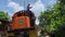 Railroad worker stands on top of the locomotive train engine to clear and cut cable obstacles along the dense slum community area