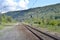 Rails and a dirt road in the forest area.