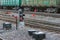 Rails with freight cars in the background and a semaphore with a glowing red light in the foreground.