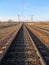 The railway is among the bleak autumn landscape.