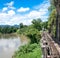 A railway bridge alongside River Kwai is a river in western Thailand at Kanchanaburi province with cloudy blue sky day.