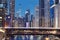 Railway bridge over Chicago River amidst illuminated city