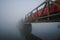 Railway Bridge With Red Train In The Fog