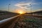 Railway in the countryside and sunset, Railroad and station, On the sides are lighting poles  Lamppost , railway