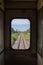 Railway crossing or junction road with railroad view from window or door mirror inside the train bogy.