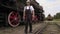 Railway employee walking near locomotive on rails