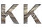 Railway font. The letter K is cut out of white paper against the background of railroad rails, mirror background for convenience.